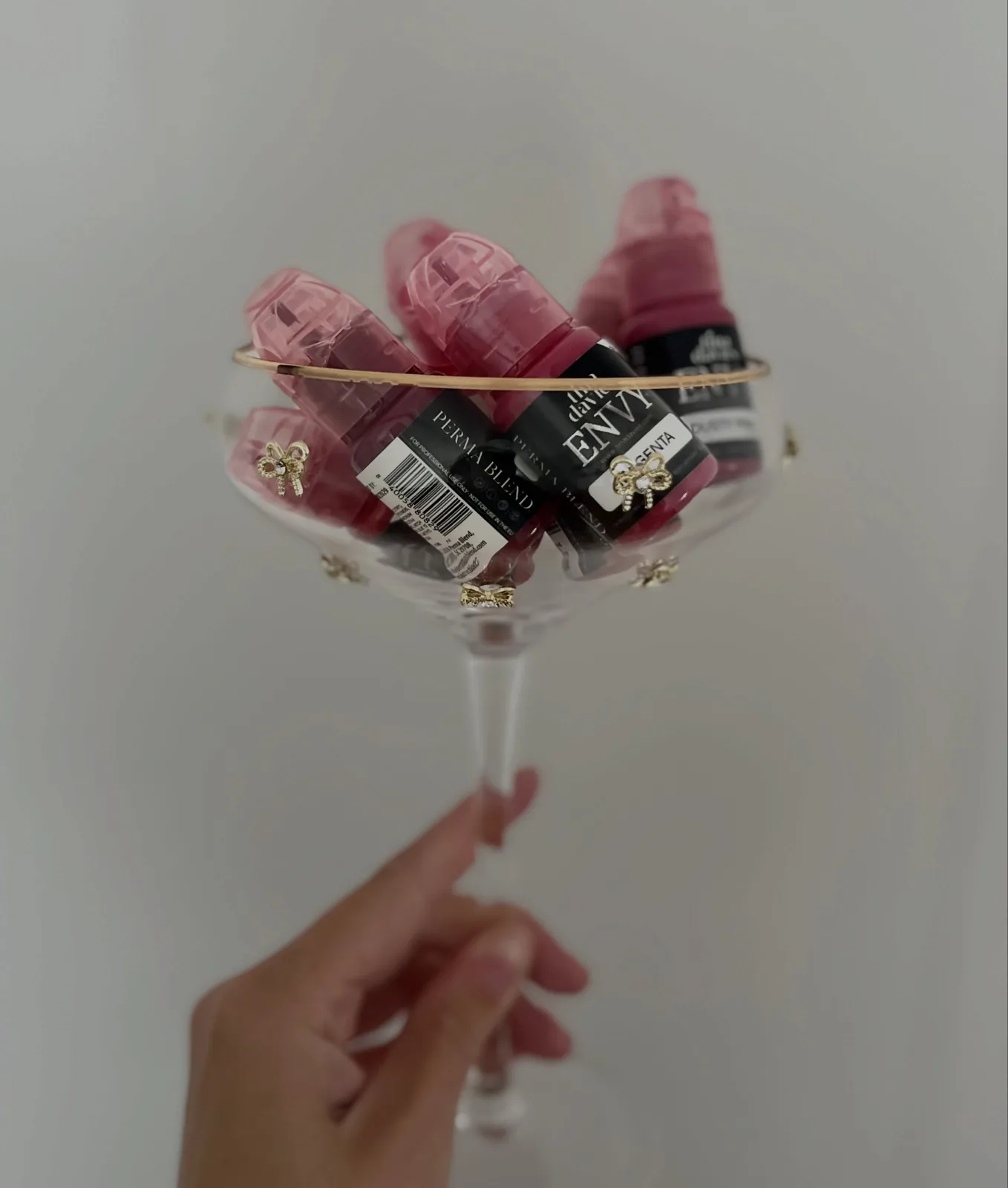 Flacons de pigments de maquillage permanent présentés dans une coupe en verre